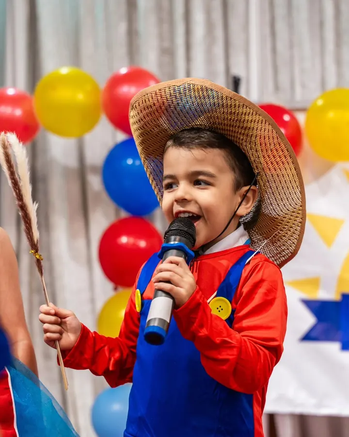 A child speaking into a microphone at a Nurtaqwa Kindergarten event.