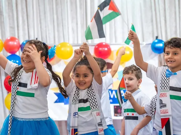 Children celebrating together with flags at Nurtaqwa Kindergarten.
