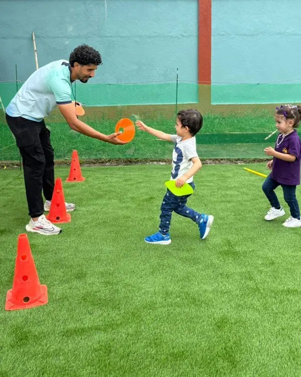 A teacher and children taking part in an outdoor learning activity at Nurtaqwa Kindergarten.